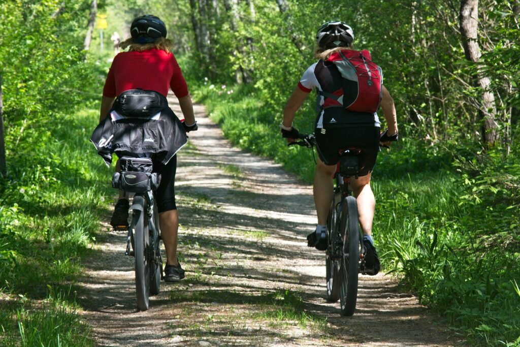 photo de deux cyclistes se baladent à vélo dans les bois 